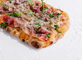 square pizza with prosciutto and arugula photo