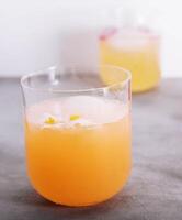 lentes de naranja jugo con hielo cubitos foto
