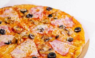 pizza with ham and mushrooms on a light background photo