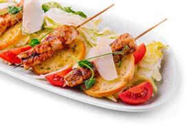 trendy Caesar salad with chicken on wooden skewers photo