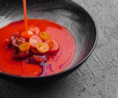 Tomato soup in a black bowl photo