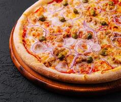 Delicious pizza Tuna with tomatoes, olives, onion and capers photo