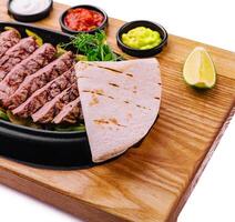 sliced fried meat with grilled vegetables and pita bread photo