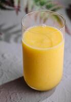 Yellow smoothie of mango, banana and orange photo