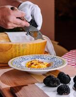Chef Grating Truffle Shavings on Pasta with Parmesan photo