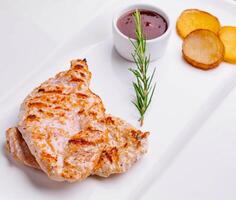 Grilled chicken breast with french fries slices of rustic photo