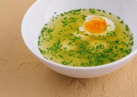 pollo sopa con huevo y eneldo en blanco cuenco foto