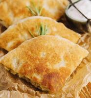 Delicious pies filo pastry with chicken, spinach and feta close-up on the table photo