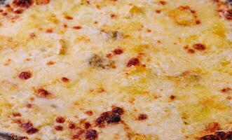 black pizza with cheese close up photo