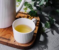 japonés verde té en blanco taza y tetera foto