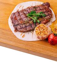 Grilled Tenderloin steak with vegetables on wood photo