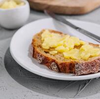 A knife spreading melted butter on bread photo