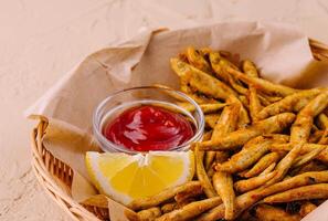 fried fish with lemon and ketchup photo