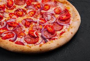 tasty pepperoni pizza with red chili pepper and onion photo