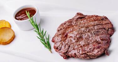 big juicy steak with potatoes on plate photo