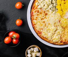 different types of cheese on a big pizza photo