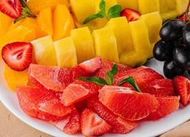 assorted sliced tropical fruits on plate photo