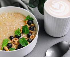 Oatmeal porridge with hazelnuts and blueberries in bowl photo