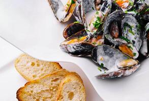 plato de sabroso mejillones con perejil y tostado un pan foto