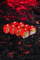 vibrante rojo caviar Sushi rodar en texturizado negro superficie foto