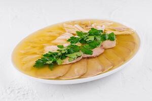 Traditional chicken aspic with parsley garnish photo
