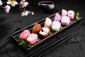 Assorted mochi ice cream on dark slate background photo