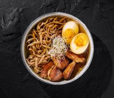 Savory ramen bowl with eggs and pork photo