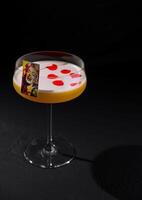 Elegant cocktail with artistic garnish on dark background photo