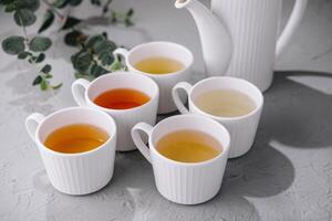 variedad de tés en blanco cerámico tazas foto