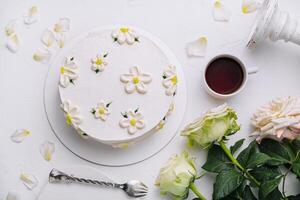 Elegant white floral cake with tea setting photo