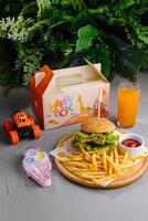 Kid's meal with toy and juice on table photo