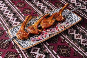 Spicy grilled lamb chops on ornate plate photo