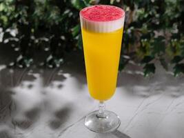 Refreshing tropical mimosa cocktail with frothy top photo