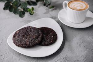 Fresh coffee and chocolate cookies on textured background photo