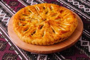 Traditional georgian khachapuri bread on ethnic tablecloth photo