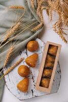 Artisanal bread rolls with wheat on rustic tabletop photo