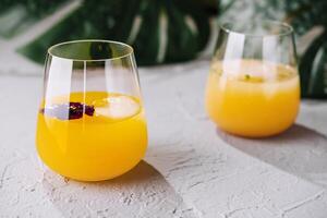 Fresco naranja jugo en elegante sin tallo lentes foto