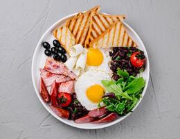 Full breakfast plate with eggs, bacon, and toast photo