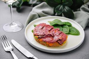 Gourmet beef tenderloin on toast with spinach photo