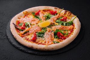 Gourmet smoked salmon pizza on dark background photo