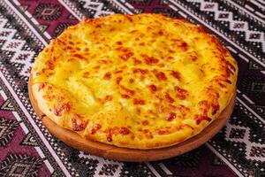 Delicious cheese pizza on traditional tablecloth photo