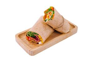 Fresh chicken wrap sandwich on wooden board photo