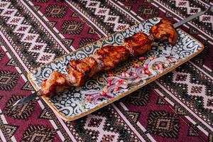 Traditional grilled meat skewers on ornate plate photo