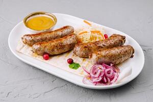 Grilled sausages with sauerkraut and mustard on plate photo