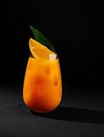 Refreshing orange cocktail on black background photo