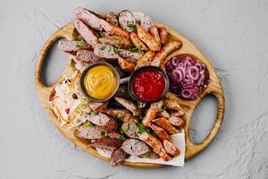 Assorted grilled sausages platter with dips photo