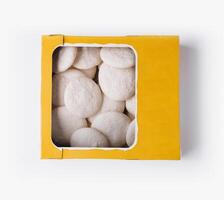 Box of vanilla meringue cookies on white background photo