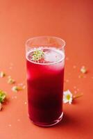 Refreshing berry smoothie with floral garnish photo