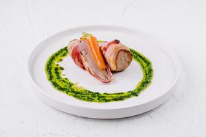 Gourmet pork tenderloin with carrot and pesto sauce photo