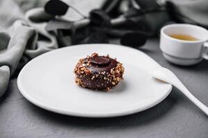 elegante chocolate postre en blanco plato con té foto